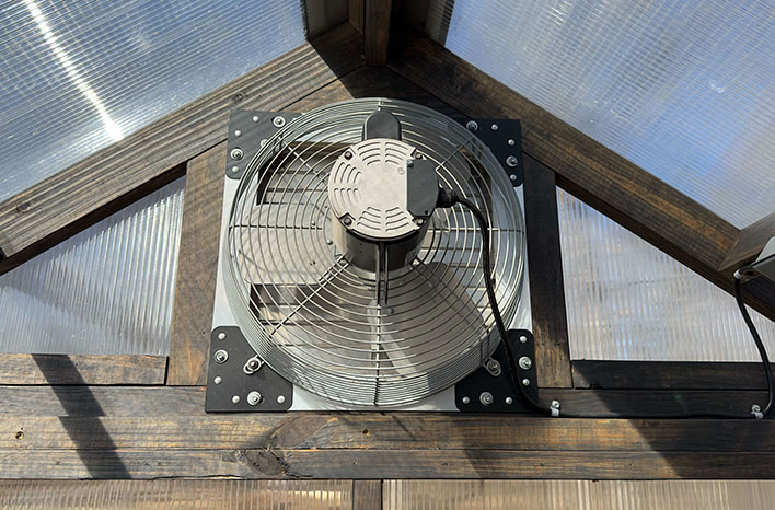 A ventilation fans moves hot air out of the greenhouse