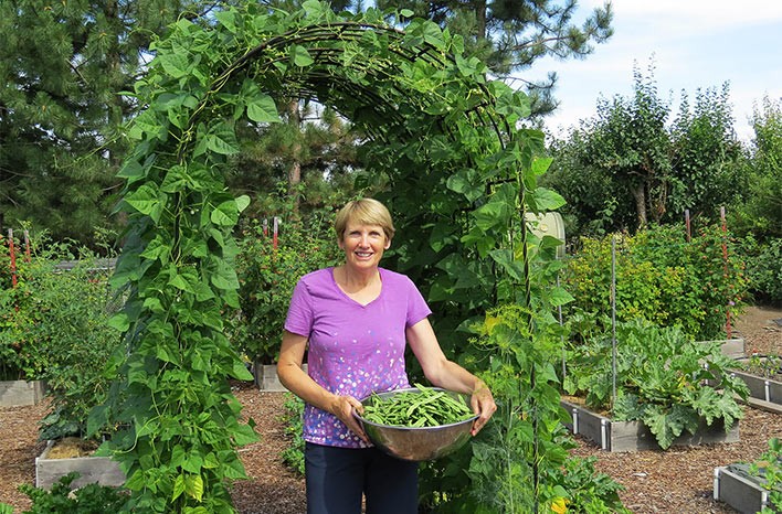 Susan Mulvihill under bean arbor